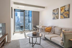 a living room with a couch and a table at Light Filled 2br Southbank Parking Pool in Melbourne