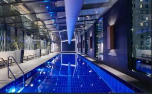a swimming pool in a building with blue lights at Light Filled 2br Southbank Parking Pool in Melbourne