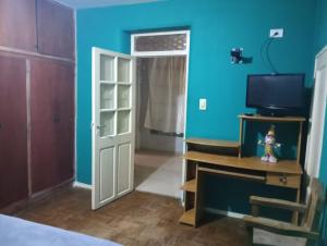 a room with blue walls and a door and a television at Hermosa casa para vacaciones in Guaymallen