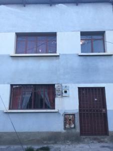 a white building with two windows and a door at Mi casa tu casa. My house in La Paz