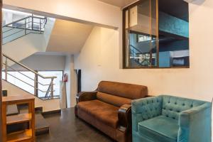 a living room with a couch and a chair at Treebo Trend Blossom - Viman Nagar in Pune