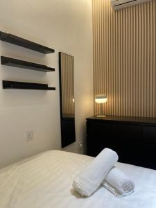 a bedroom with a bed with two towels on it at K Avenue by Tiara in Donggongon