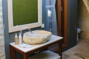 a bathroom with a stone sink on a table at Ammora 1 BR Deluxe Suite NE60 in Gili Air