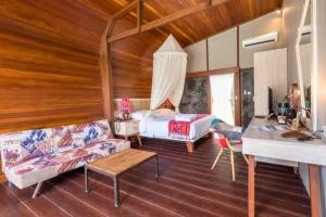 a living room with a bed and a couch at Ammora 1 BR Deluxe Suite NE60 in Gili Air