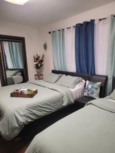 a bedroom with two beds and a mirror and blue curtains at Contemporary California Bungalow in Brea