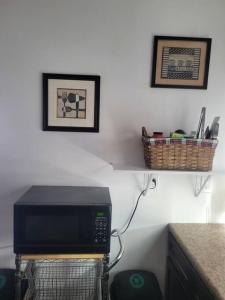 a microwave in a kitchen with a basket on the wall at Contemporary California Bungalow in Brea