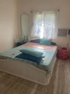 孟買的住宿－Boho connection，一间卧室配有一张带蓝色枕头的床。