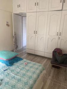 a room with a bed and white cabinets at Boho connection in Mumbai