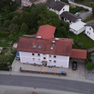 a large white house with a red roof at Ferienwohnung Niedermoosen in Riedering