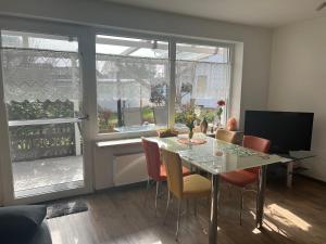 a dining room with a table and chairs and windows at Ferienwohnung Niedermoosen in Riedering