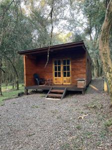 a small wooden cabin with a porch in a forest at Jasy del monte in Leandro N. Alem