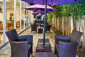 日惹的住宿－日惹大蘭花酒店，一组椅子和一张桌子及一把伞
