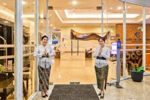 zwei Frauen, die vor einem Laden mit ihren Krawatten stehen in der Unterkunft Grand Orchid Hotel Yogyakarta in Yogyakarta