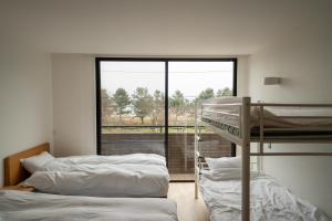 Ce dortoir comprend 2 lits superposés et une fenêtre. dans l'établissement Biwako Galaxy, à Katsuno