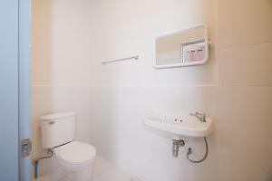 a white bathroom with a toilet and a sink at มิตร อินน์ เยาวราช Mitr Inn Yaowarat in Khlong San