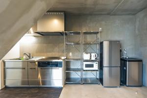 uma cozinha com electrodomésticos de aço inoxidável num quarto em Nashiro White Cube - Vacation STAY 14460 em Itoman