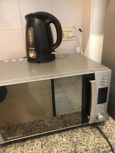 a tea kettle is sitting on top of a microwave at Departamento 3 ambientes en Resistencia in Resistencia