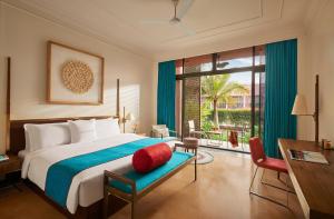 una camera da letto con un letto, una scrivania e una finestra di Storii By ITC Hotels Devasom Resort & Spa, Kolkata a Bāruipur