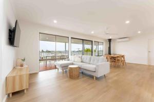 a white living room with a couch and a table at The Gooldives- Family and pet friendly- WIFI in Goolwa South