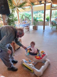 Un uomo che spinge un bambino in un'auto giocattolo di HELEN aparment ad Argostoli