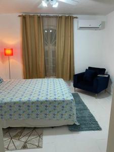 a bedroom with a bed and a blue chair at K2 Aqua Vista Escape in Ocho Rios