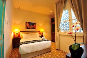 Postel nebo postele na pokoji v ubytování Kapitan Kongsi Boutique Hotel