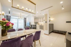 comedor con mesa y sillas moradas en Vera Saigon Apartments - Vinhomes Central Park, en Ho Chi Minh