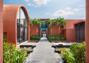 un edificio con palme e un vialetto di Storii By ITC Hotels Devasom Resort & Spa, Kolkata a Bāruipur