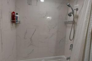 a white bathroom with a shower and a tub at Cozy 2-Bedroom Basement Guest Suite with Private Entrance and Proximity to the Airport in Edmonton +31 photos