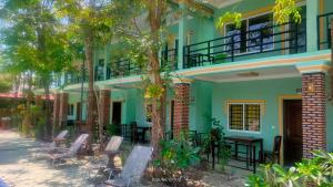 a building with chairs and tables in front of it at Jasmine Resort Kampot in Kampot