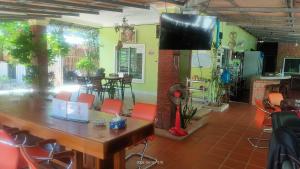 una sala da pranzo con tavolo, sedie e TV di Mabuhay Guesthouse Kampot former Jasmine Resort Kampot a Kampot