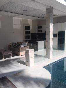 een woonkamer en een zwembad in een huis bij Hasta La Vista Villa Amed in Amed
