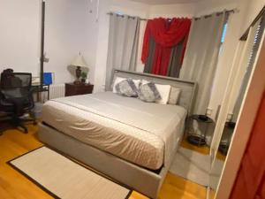 a bedroom with a bed and a window with curtains at Harmony place to stay close to all fun in Jersey at 15 minutes to NY City in North Bergen