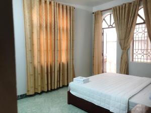 een slaapkamer met een bed en een groot raam bij Hotel Nam Sơn Tân Dương in Hoàng Mai