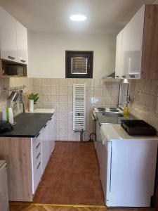 a small kitchen with white cabinets and a sink at Kuća sa pogledom na Tornik in Zlatibor