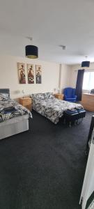 a bedroom with two beds and a blue chair at The Hive Great Yarmouth in Great Yarmouth