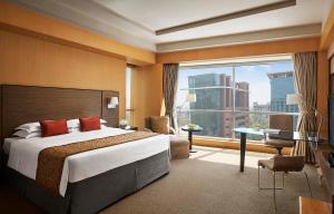 a hotel room with a bed and a large window at Grand Hyatt Mumbai Hotel and Residences in Mumbai