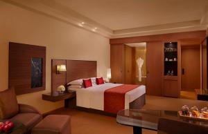 ムンバイにあるGrand Hyatt Mumbai Hotel and Residencesのベッドとソファ付きのホテルルーム