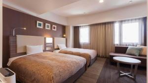 Habitación de hotel con 2 camas y sofá en Onomichi Royal Hotel, en Onomichi