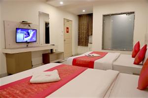 a hotel room with two beds and a flat screen tv at Hotel Klick International in New Delhi