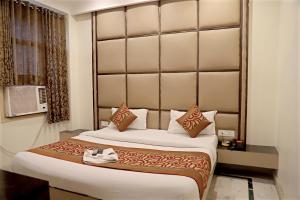 a bedroom with a large bed with a large headboard at Hotel Klick International in New Delhi