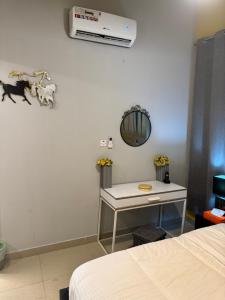 Habitación con cama, mesa y espejo. en شقة سليب تايم, en Al Ain