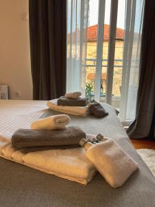 two towels are sitting on a bed with a window at Apartman Malena in Trebinje