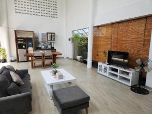 a living room with a couch and a tv at Jadin Villa at Nusa Dua Bali in Nusa Dua