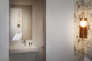 a bathroom with a sink and a mirror at Le Mireille in Paris