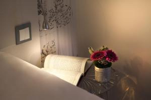 a table with a book and a vase with a flower at Le Mireille in Paris