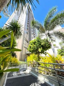 a walkway with palm trees and a tall building at A city escape at the Avida Towers Aspira 1 in Cagayan de Oro