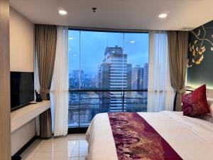 Schlafzimmer mit einem großen Fenster mit Stadtblick in der Unterkunft Yixuan Yasi Apartment-free shuttle during the Canton Fari in Guangzhou