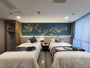 a hotel room with two beds and a blue wall at Yixuan Yasi Apartment-free shuttle during the Canton Fari in Guangzhou