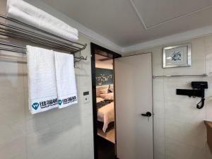 ein Schlafzimmer mit einem Bett und einer Tür mit einem Fenster in der Unterkunft Yixuan Yasi Apartment-free shuttle during the Canton Fari in Guangzhou